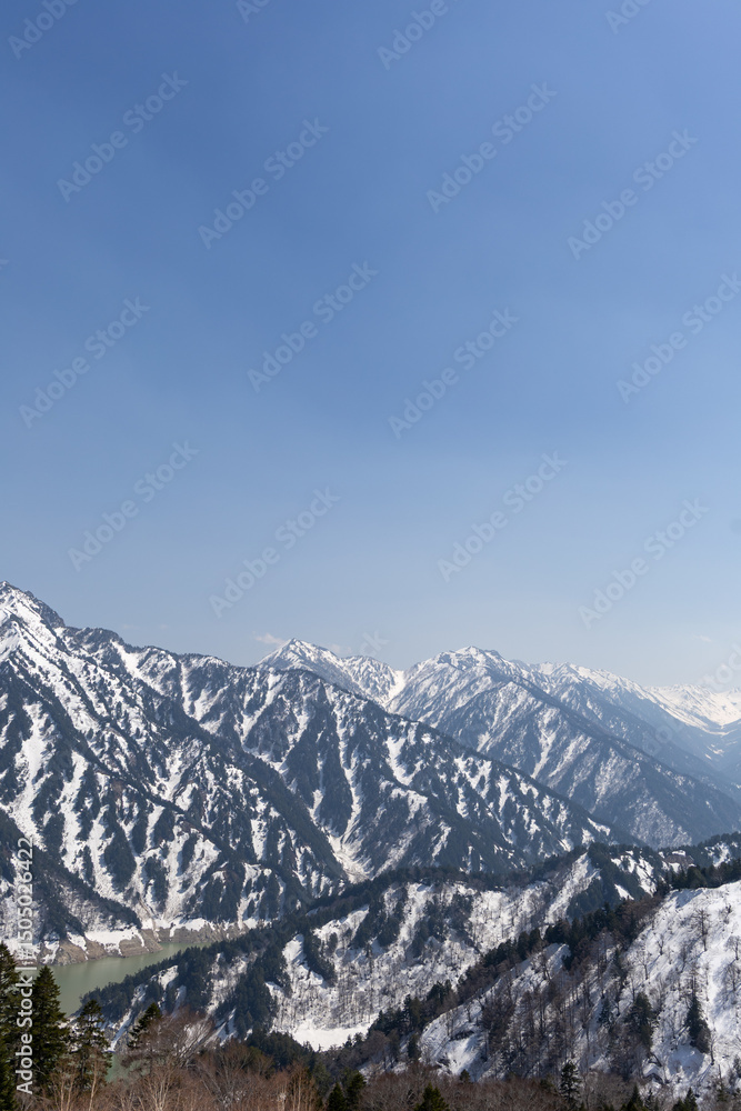 Fototapeta premium 黒部平パノラマテラスから見下ろす黒部湖と雪山の風景 