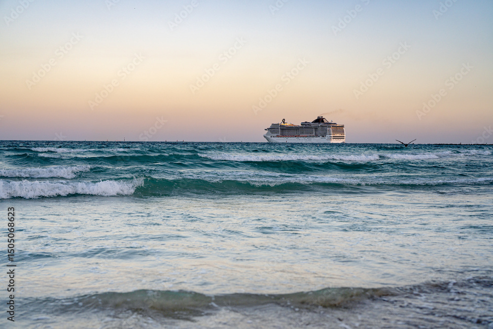 Obraz premium Cruise ship on the ocean. Luxury liner at ocean. Miami Beach with cruise ship. Turquoise water and cruise liner. Tourist cruise ship near the coast. Ocean waves and vessel boat.