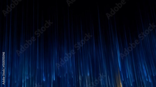Abstract blurred colorful light trails in a dark blue night backdrop creating an effect of speed and dynamism, with motion blur.