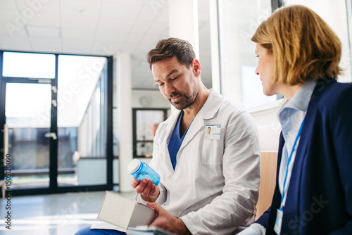 Foto Female medical sales representative introducing pharmaceutical products to doctor