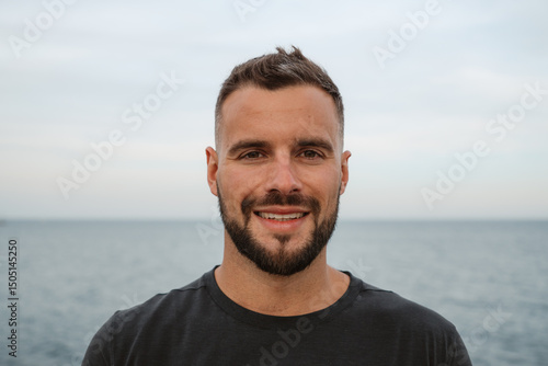Принти на полотні Portrait of a handsome smiling man with short hair and beard posing in front of