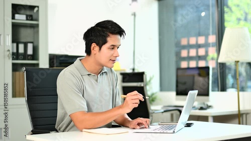 Wallpaper Mural young man working on laptop at bright modern office desk with coffee and tablet. Ideal for tech, freelance, business, and remote work Torontodigital.ca