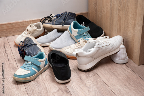 Dirty baby shoes scattered on the floor of the nursery. Decluttering and tidying up