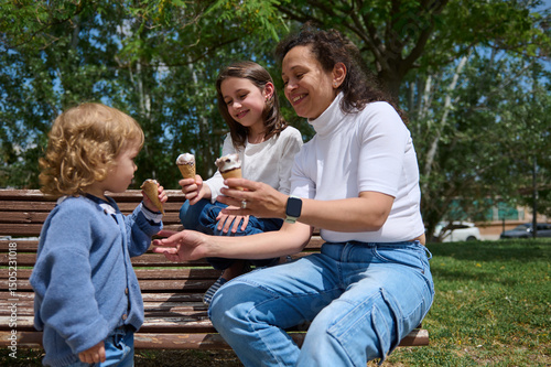 Family Enjoying Ice Cream Together Outdoors at Park on a Sunny Day