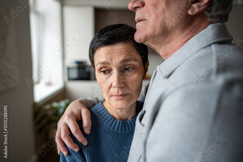Canvas Print Senior woman in husband embrace comforting thoughtful sad mood
