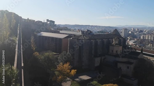 Panoramic view of Girona, Spain, from ancient fortress walls on a sunny autumn morning. Video 20 sec. Girona Cathedral tower rises above medieval rooftops and colorful cityscape with mountain horizon