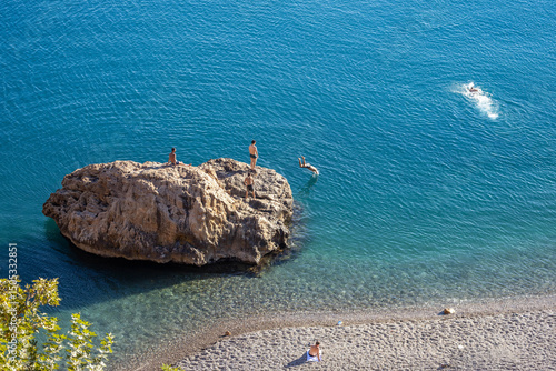 Aerial view of Konyaaltı Beach with crystal turquoise water, and coastal rock used for diving. Summer scene, Antalya, Turkey.