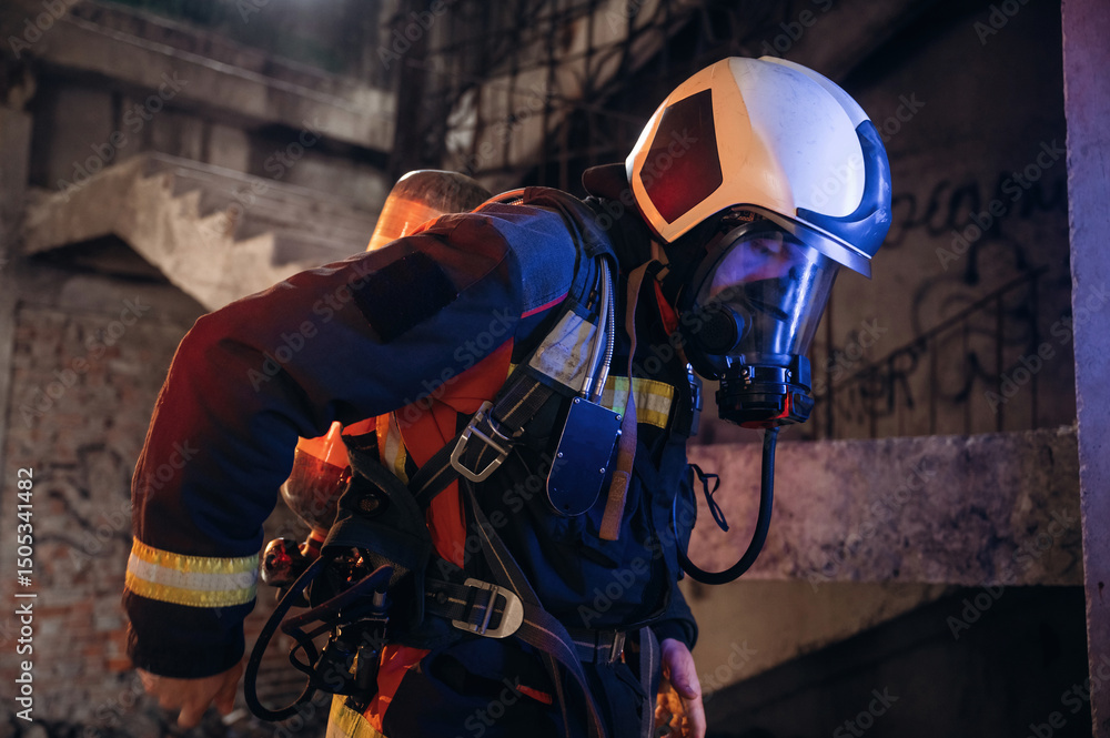 Obraz premium Adjusting air flow into the mask. Firefighter in professional equipment is indoors in abandoned building