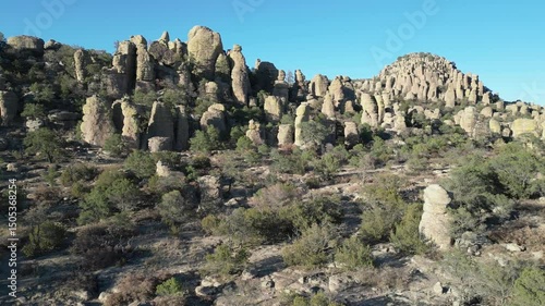 Rock spires and dry shrubs under clear sky in Valle de los Monjes, Creel, Chihuahua
