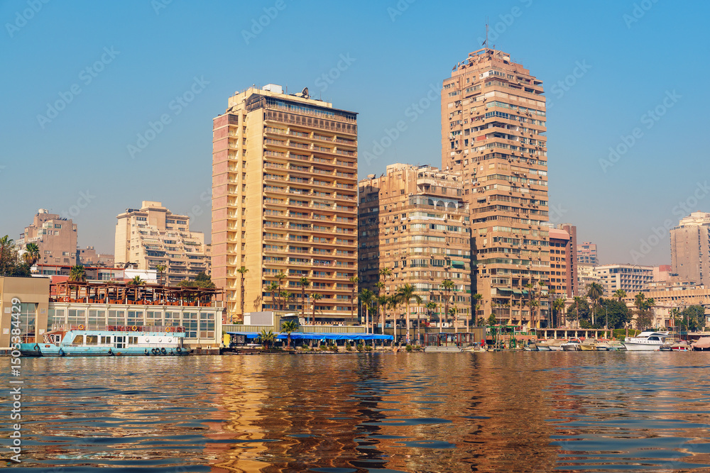 Obraz premium Vibrant waterfront view of Cairo with modern buildings and reflections during a sunny day