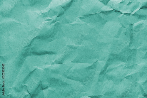 Recycled crumpled turquoise colored paper texture. Wrinkled craft paper background, rough cardboard surface, wallpaper, backdrop. Design element, copy space for text