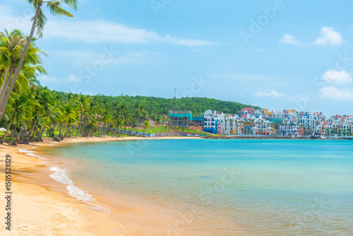 Foto Tropical beach with golden sand, turquoise sea, palm trees and colorful seaside resort buildings with nobody, Phu Quoc island, Vietnam
