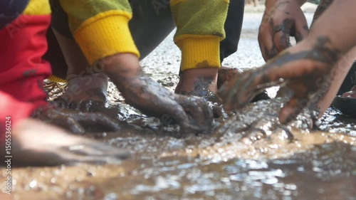 children having fun playing in the mud.  children's hands full of mud