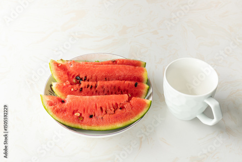The white water cup and the watermelon in the white plate