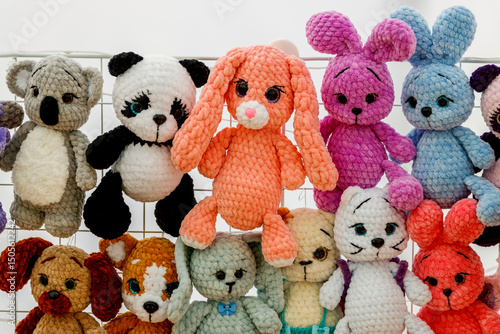 Canvas Print Many colorful knitted amigurumi toys: koalas, pandas, bunnies, and others, on a grid background