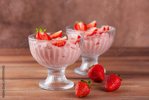 Whipped tofu and strawberry mousse pink dessert in a glasses on a table. Vegan food. Lactose and sugar free.
