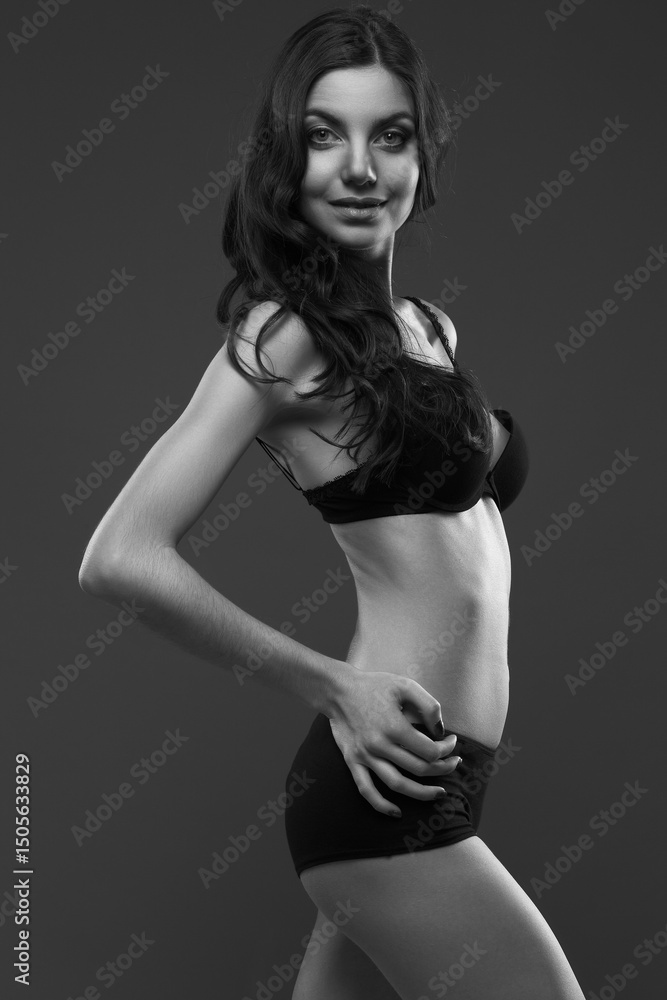Fototapeta premium young slim girl in black lingerie on dark gray background