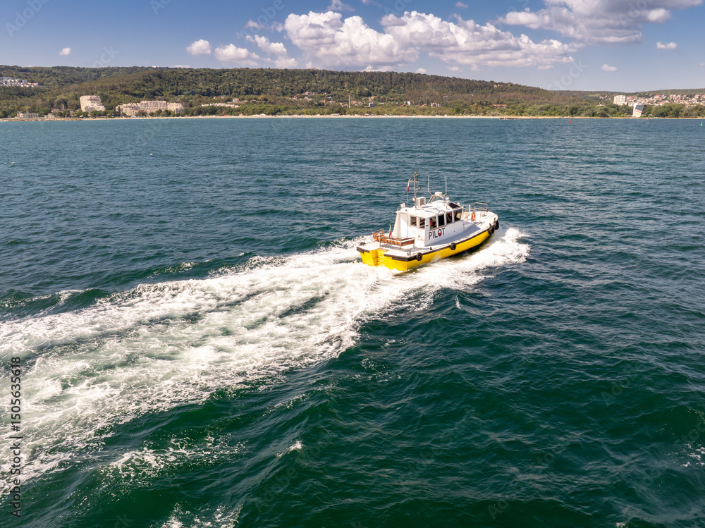 Fototapeta premium Pilot boat crashing through waves, going to a cargo ship.