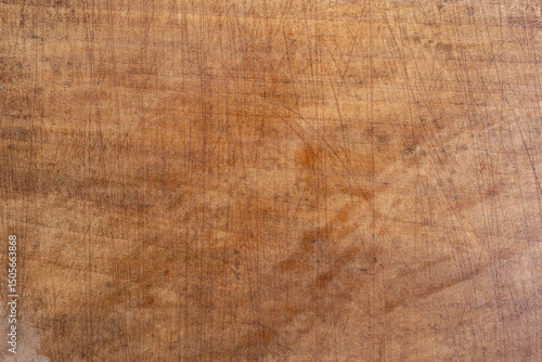 Overused chopping board with cuts and scratches, soft focus close up
