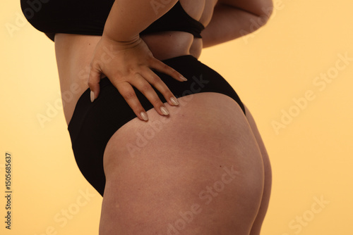 Detailed View of a Womans Hip and Buttocks on Neutral Background photo