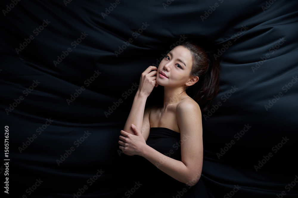 Fototapeta premium Elegant Asian Woman in Black Strapless Dress, Artistic Studio Portrait on Dark Background