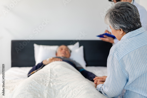 Foto scene of bedridden patient, back view of wife illness's relative holding hand el