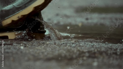 Walking in rubber boots through puddles on a rainy day. splashes of water