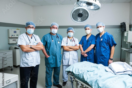 Medical team standing by hospital bed in a sterile operating room environment