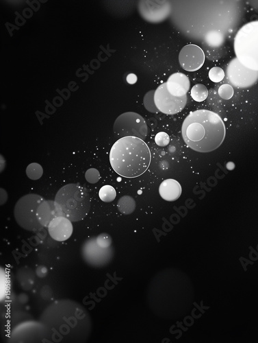 An abstract black and white image features a collection of translucent, overlapping bubbles of varying sizes. The bubbles are scattered across a dark background, creating a sense of depth and movement