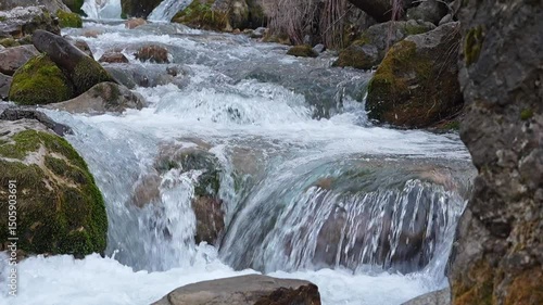 Video of a beautifully flowing mountain river with rapids and small waterfalls with sound and 100 fps with a first-person view. Natural spaces far from urban life, the world's water cycle