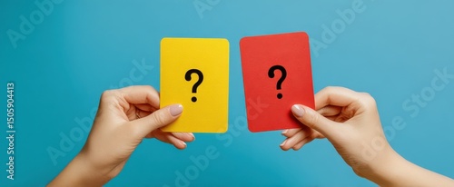 The hands holding yellow and red question cards against a blue background.