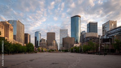 A city's skyline of commercial buildings is seen from an empty plaza.