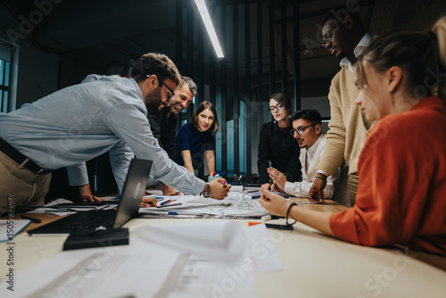 Billede på lærred A multicultural group of business people collaborates around a table, engaged in an energetic discussion