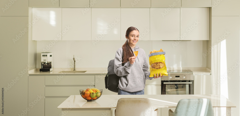 Teenage female student eating crisps and smiling Teenage female student eating crisps and smiling