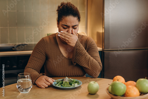 Female suffers from eating disorder and feeling nausea at the kitchen