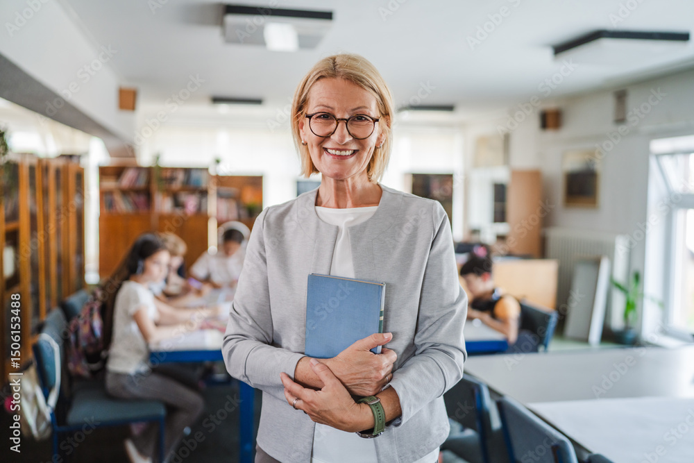 Obraz premium Portrait of smile mature woman teacher librarian stand with book