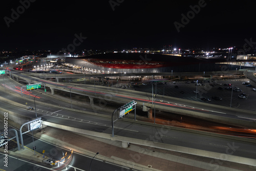 Night view of Boston airport with light trails from cars on the highway.