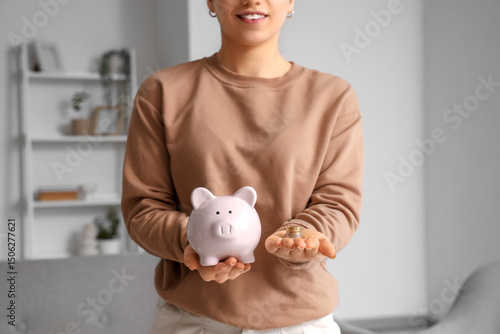 Young woman holding piggy b...