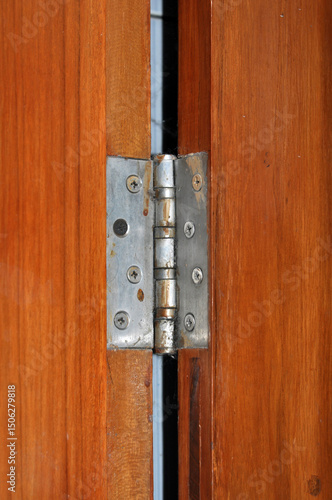 a dull iron hinge on a wooden door