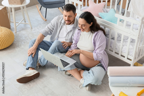 Young pregnant couple using...