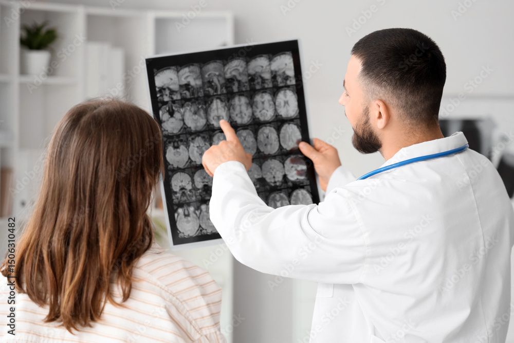 Fototapeta premium Male doctor showing MRI scan of head to woman in clinic, back view
