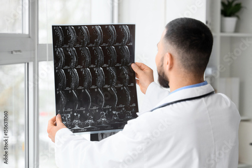 Male doctor studying MRI sc...