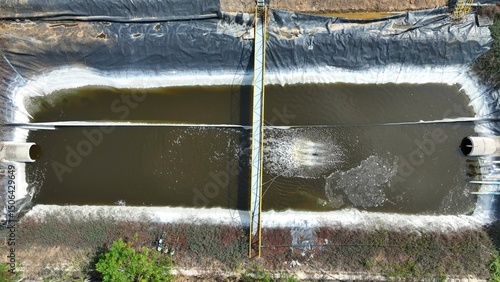 An aeration unit operates at full force in an effluent pond, showing a vigorous splash pattern that enhances circulation and supports waste processing.
