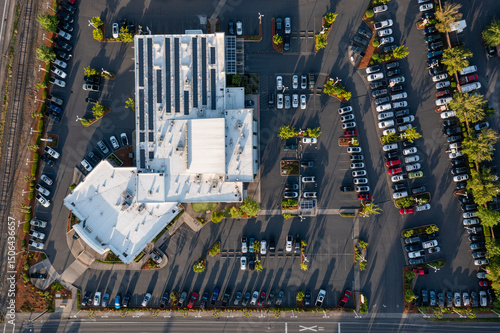Aerial drone top-down view of a busy and full parking lot at a large car dealership in Beaverton, Oregon, with many parked cars and clearly marked driving lanes	
