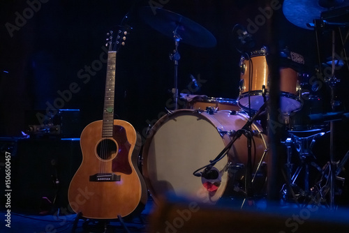 A Guitar and Drum Set on a Dark Moody Stage at a Venue for a Local Live Music Concert