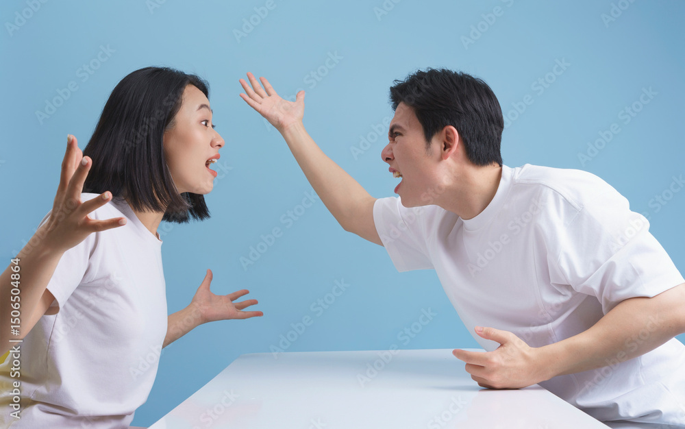 Emotional conversation between two young adults in casual attire against a light blue background Emotional conversation between two young adults in casual attire against a light blue background