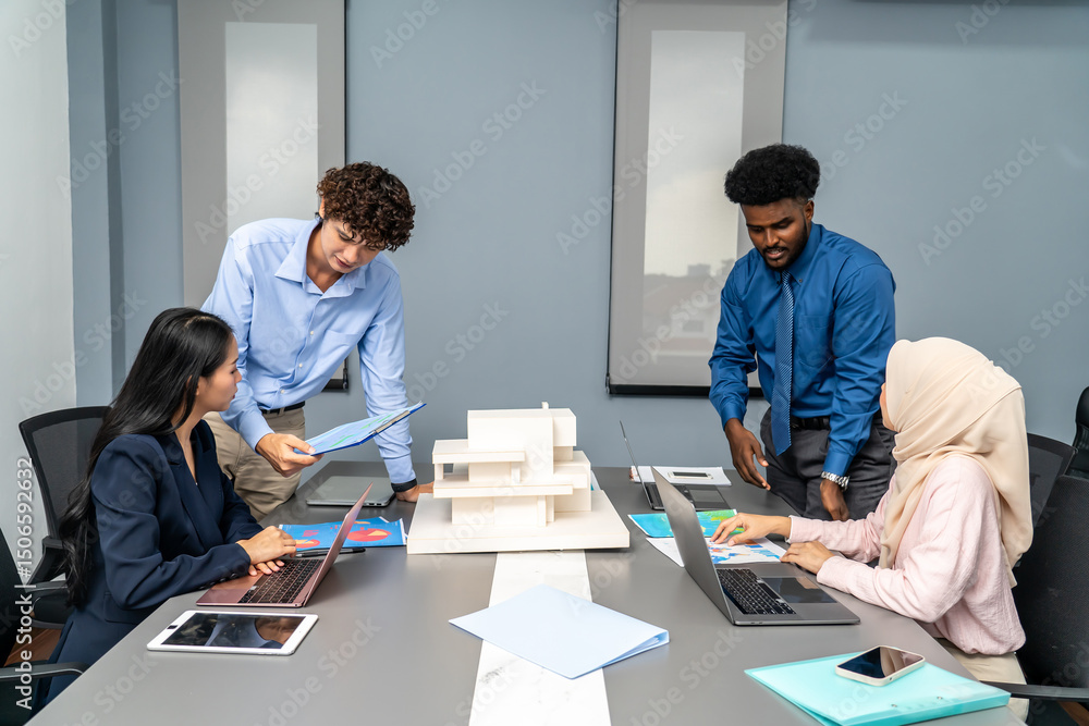 Architects and designers work presenting and discussing house model in office meeting. The participants are engaged in an in-depth conversation, Experts look at model homes and architectural drawings Architects and designers work presenting and discussing house model in office meeting. The participants are engaged in an in-depth conversation, Experts look at model homes and architectural drawings