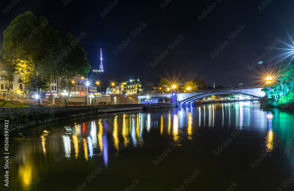 Night view of the Kura (Mtkvari) river with reflections of lantern light. Metekhi Bridge, Mtatsminda Park, funicular and TV tower. Night view of the Kura (Mtkvari) river with reflections of lantern light. Metekhi Bridge, Mtatsminda Park, funicular and TV tower.