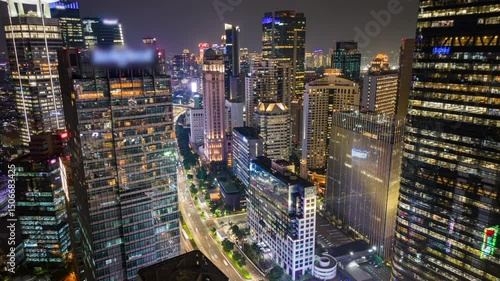Aerial timelapse of Jakarta business district at night with busy traffic, illuminated skyscrapers, and city skyline. Ideal for city, business, travel, and infrastructure themes.