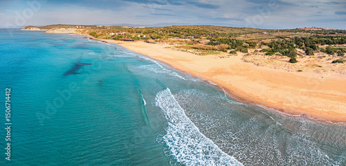 Fototapeta Naklejka Na Ścianę i Meble -  Aerial view of waves reaching a beautiful beach with turquoise water and golden sand on a sunny summer day
